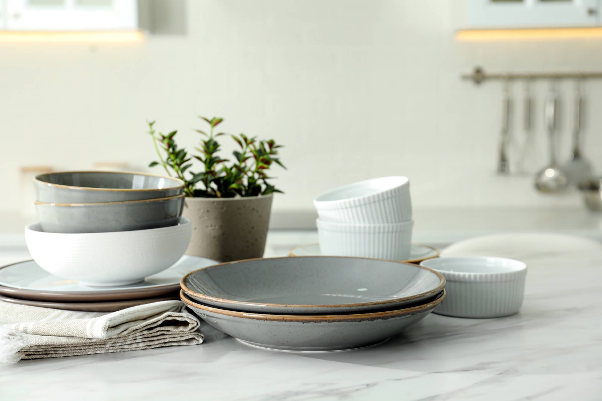 Set of beautiful ceramic tableware on white table in kitchen