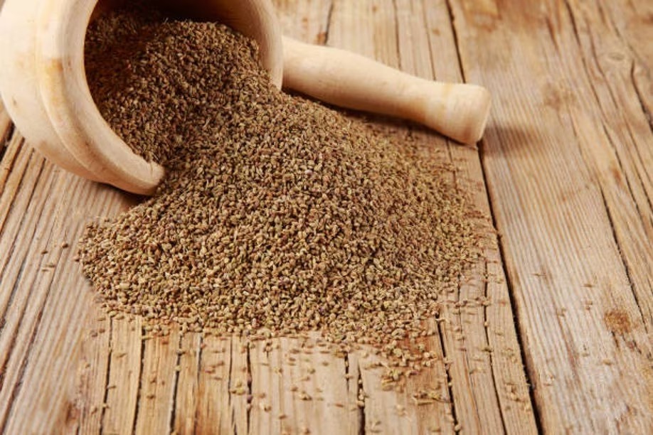 Cumin seeds being ground in a mortar and pestle