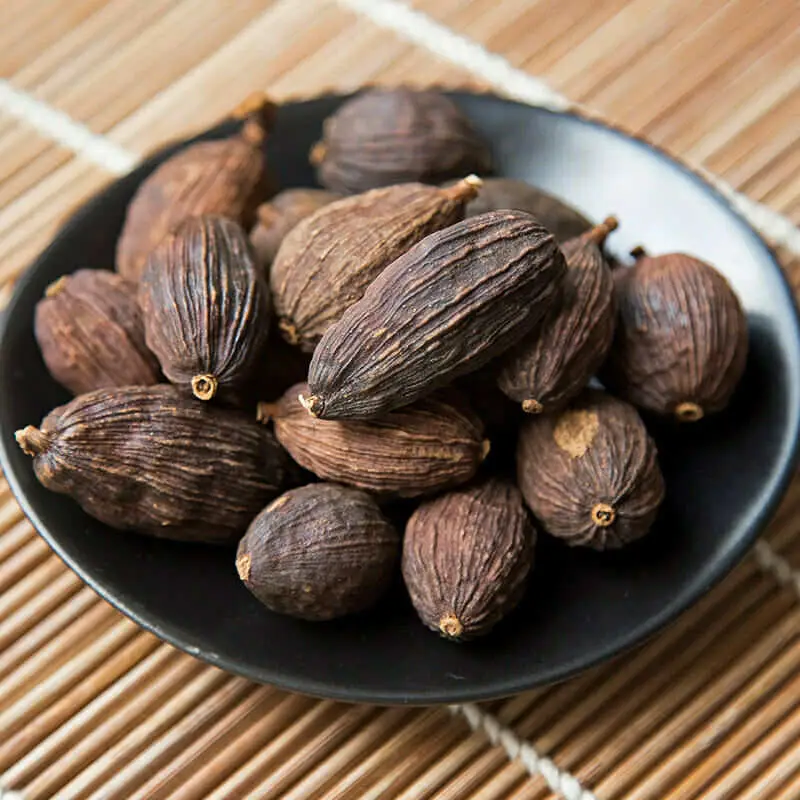  A bowl of dried cashews on a table with black cardamom