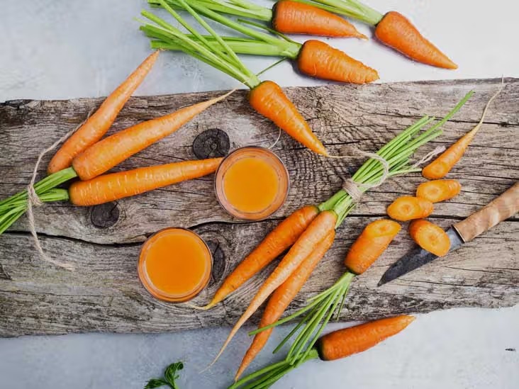 Carrots and juice on a wooden table