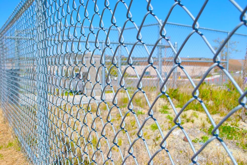 A chain-link fence in a field, providing security and boundary