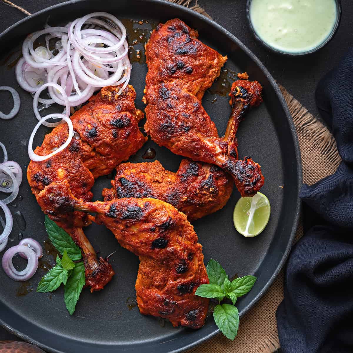 Tandoori chicken wings served on a plate with onions and lime