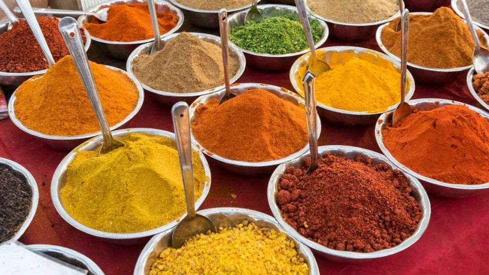 A colorful assortment of Indian spices and herbs displayed in bowls