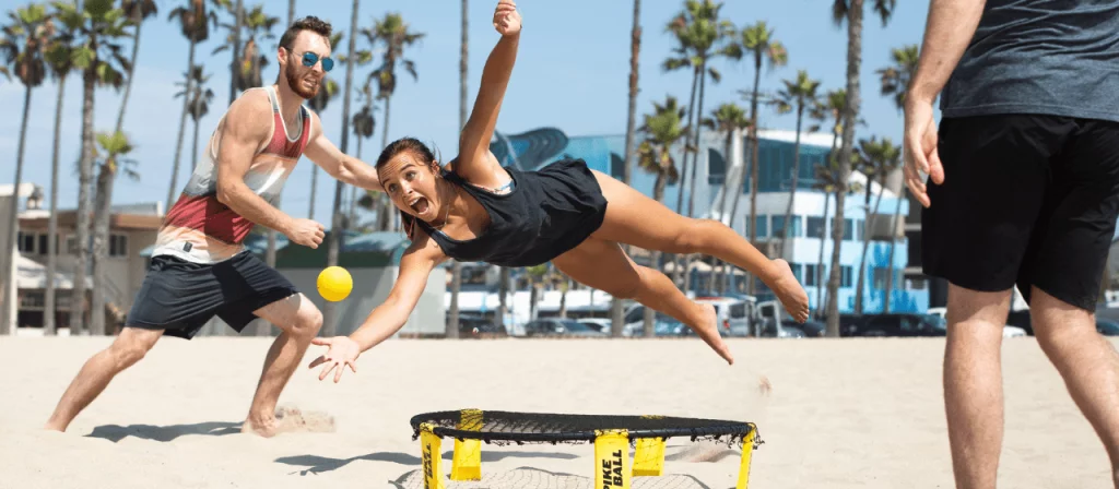 people playing spikeball on the beach